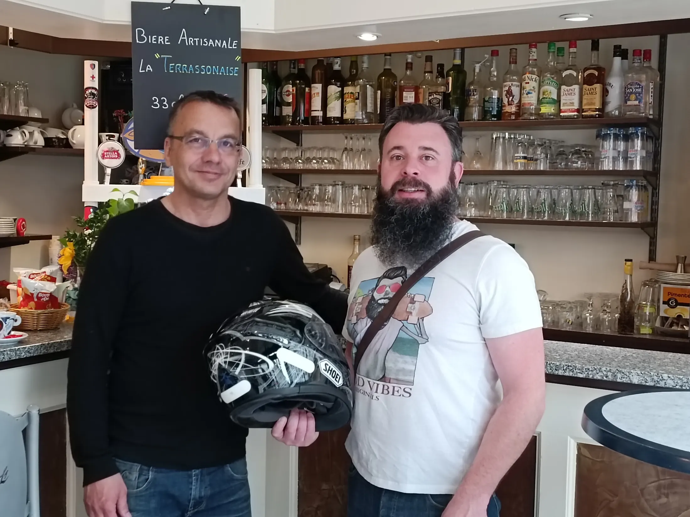 Un commerçant remettant un casque de moto à un motard